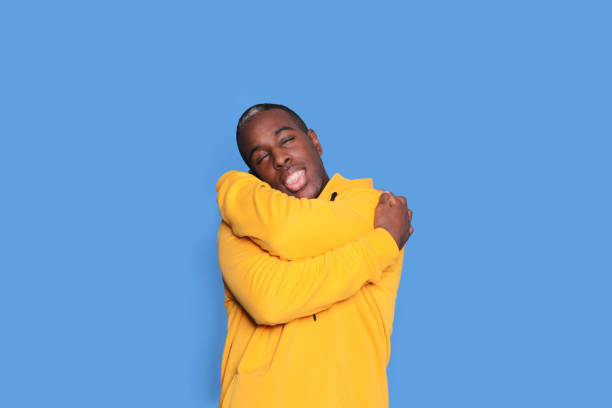 istock Happy man hugging himself in a yellow hoodie 2178660102
