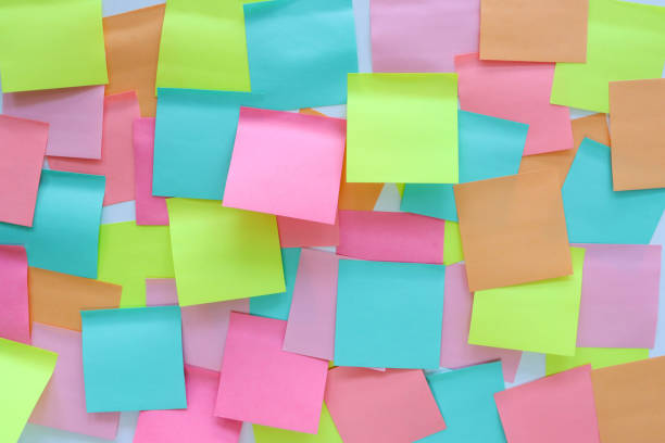 istock Full frame image of multicoloured sticky notes stuck to white wall, overlapping blank adhesive papers for note taking, yellow, orange, turquoise blue and pink paper squares, stationery, focus on foreground, Ideation and Creative thinking concept 2178660223