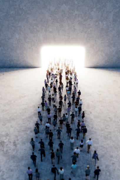 istock Crowd of people walking towards bright light gate in large space 2178660442
