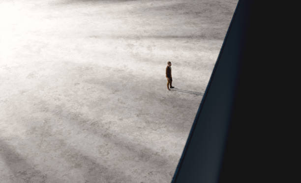 istock Man standing alone in large empty area in front of precipice 2178660446