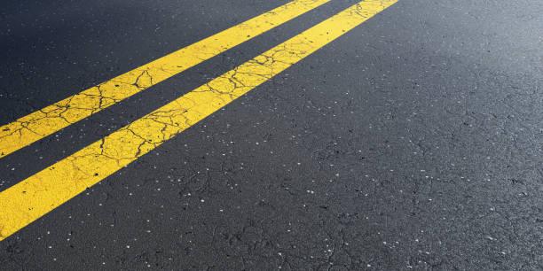 istock Asphalt road with bright yellow double lines and cracks 2178660473