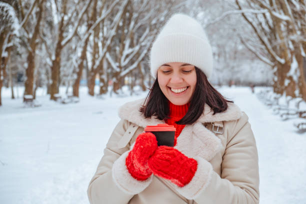 istock happy woman with coffee cup outdoors at winter cold day 2178661353