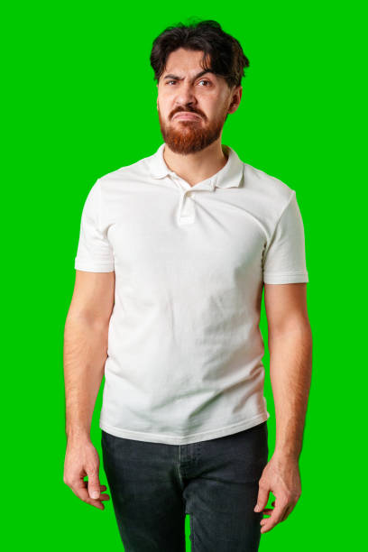 istock A young man with a beard showing a serious expression against a vibrant green background 2178661982