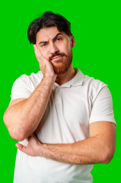 istock A man with a serious expression stands against a vibrant green background 2178661985