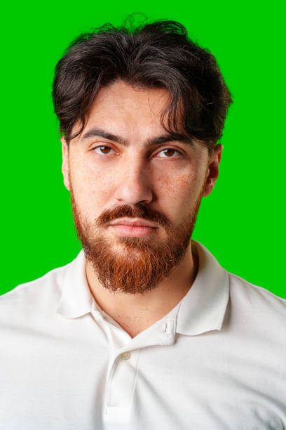 istock A man with a serious expression stands against a vibrant green background 2178663110