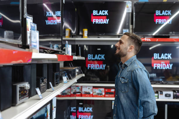 istock Man shopping for a TV during Black Friday sales event at electronics store 2178664138
