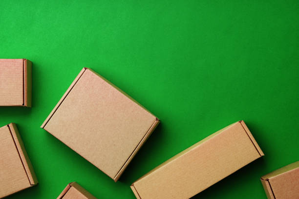 istock Brown cardboard boxes arranged on a vibrant green surface 2178665226