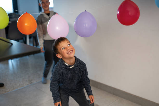 istock Smiling boy playing with colorful balloons at home party 2178665808