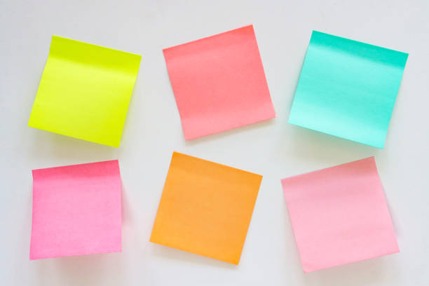 istock Full frame image of multicoloured sticky notes stuck askew to white wall, two rows of six blank adhesive papers for note taking, yellow, pink, turquoise blue and orange paper squares, stationery, focus on foreground, Ideation and Creative thinking 2178666773