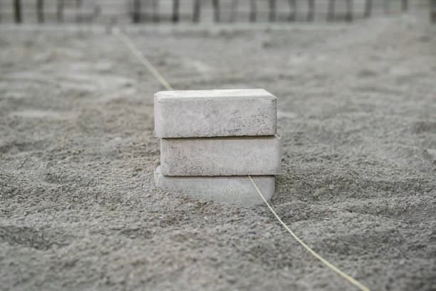 istock Concrete blocks anchored in sandy terrain, supporting a measuring line for construction or landscaping work at a worksite 2178666893