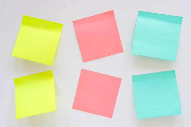 istock Full frame image of multicoloured sticky notes stuck askew to white wall, two rows of six blank adhesive papers for note taking, yellow, pink and turquoise blue paper squares, stationery, focus on foreground, Ideation and Creative thinking 2178667086
