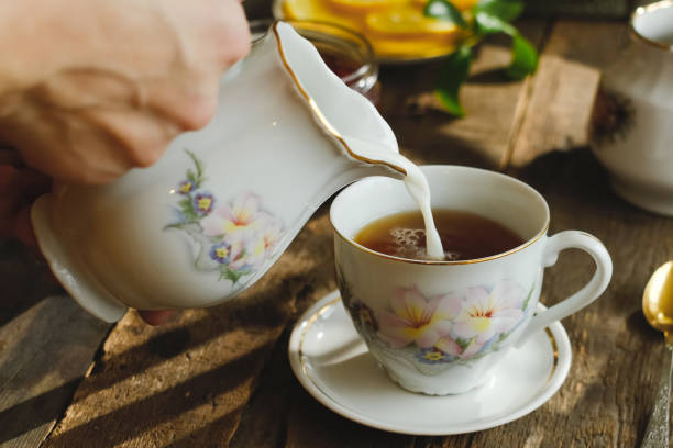 istock Tea party in rustic style. Pouring milk into tea cup. 2178668849