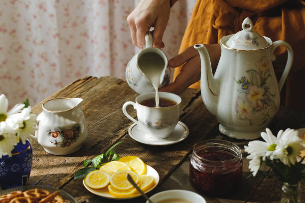istock Tea party in rustic style. Pouring milk into tea cup. 2178669956