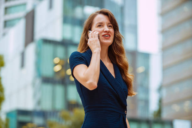 istock Businesswoman talking on mobile phone outdoors at city 2178672848