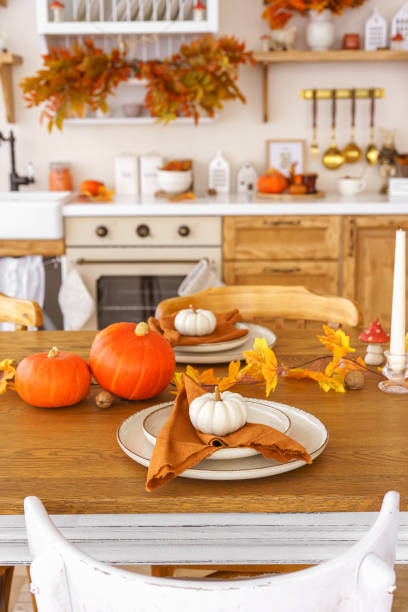 istock Dining table decorated with pumpkins and fall foliage in a cozy kitchen setting for autumn holiday 2178673419