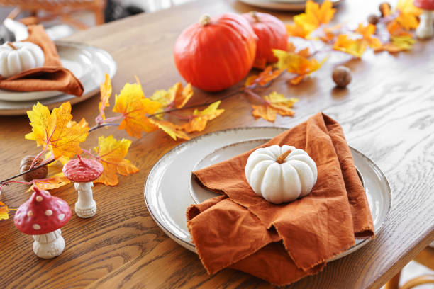 istock Autumn table setting with pumpkins and vibrant fall leaves on brown wooden table background 2178673424