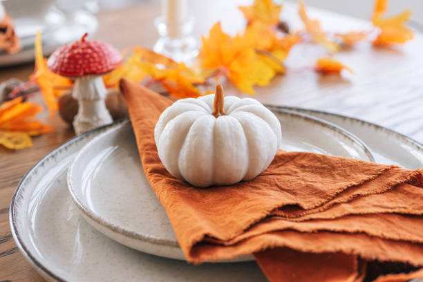 istock White decorative pumpkin on orange napkin on table autumn setting for fall holidays in warm tones 2178673428