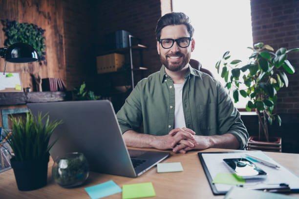 istock Photo of handsome young guy working netbook smart manager dressed green shirt comfortable startup office loft room interior 2178673562