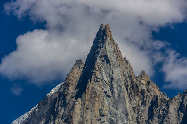 Massive vertical granite cliffs streaked with snow rise sharply in the Mont Blanc massif, revealing dramatic textures and deep shadowed crevices under crisp winter light.
