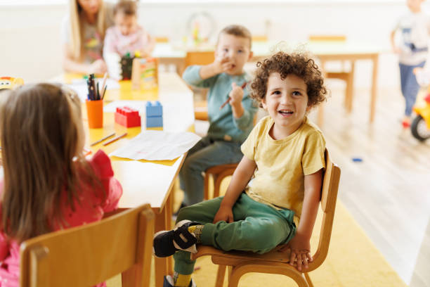istock Boy sitting on a chair while drawing whit his friends in kindergarten 2178675281