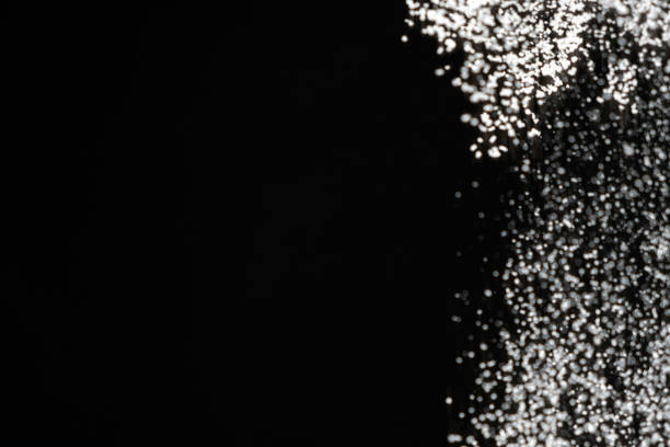 Abstract black and white background of pouring flour, space for text.