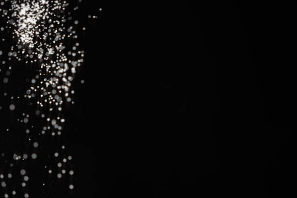 Abstract black and white background of pouring flour, space for text.