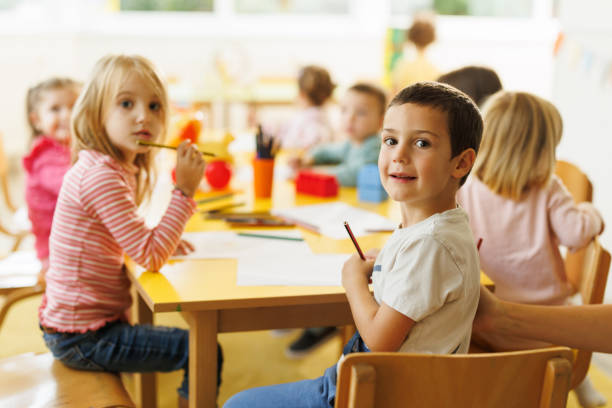istock Boy drawing whit his friends in the kindergarten 2178675825