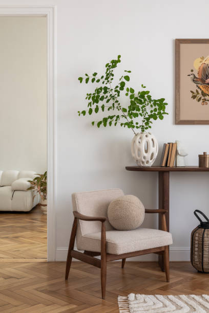 istock Interior design of white living room space with modern armchair, mock up poster frame, commode,  books, plants and personal accessories. Template. Home decor. 2178678147