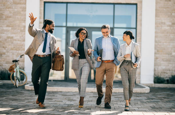 istock multi national professional business people walking and smiling outdoors in business district 2178678637