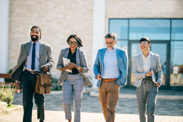 istock multi national professional business people walking and smiling outdoors in business district 2178678639