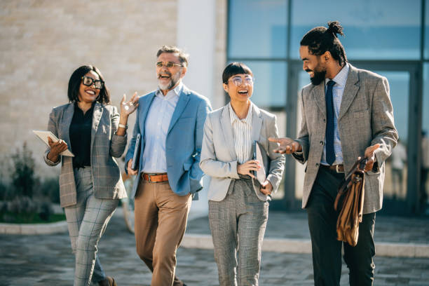 istock multi national professional business people walking and smiling outdoors in business district 2178678643