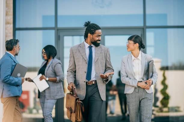 istock multi national professional business people walking and smiling outdoors in business district 2178678701