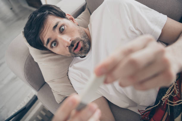 istock Surprised young man at home discovering unexpected news while relaxing on the sofa during a sunny day indoors 2178678892