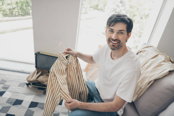 istock Young man choosing a shirt at home during a leisurely weekend afternoon 2178679029