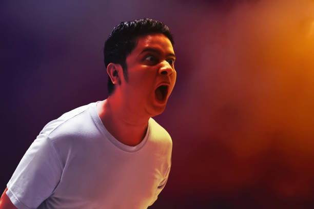 Close-up portrait of a funny crying man emotions of a handsome man guy on a green background chromakey close-up dark hair young man. Men are showing chest pain.