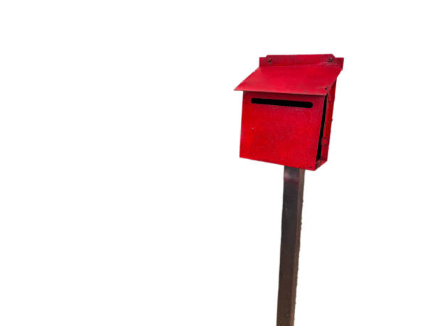 A bright red mailbox stands tall on a wooden post against a white background.