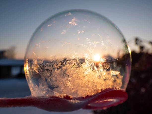 Macro shot of round, frozen soap bubble forming beautiful leaf and tree like pattern while freezing in very cold temperatures in winter