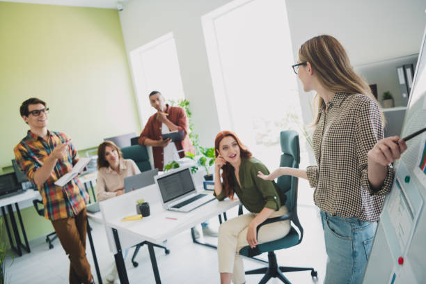 istock Photo of cheerful friendly young it coworkers discussing problems enjoying professional education listening lecture indoors workplace workshop 2178682441