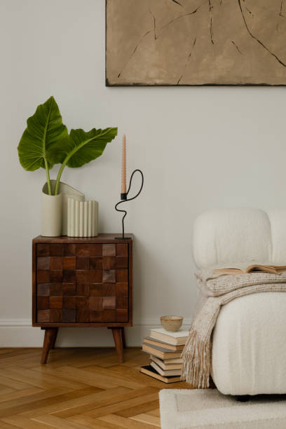 istock A stylish, minimalist living room area featuring a mid-century modern commode with a cozy decorations, leafs in vase. The room includes elegant decor, soft lighting, and a tranquil ambiance. 2178684611