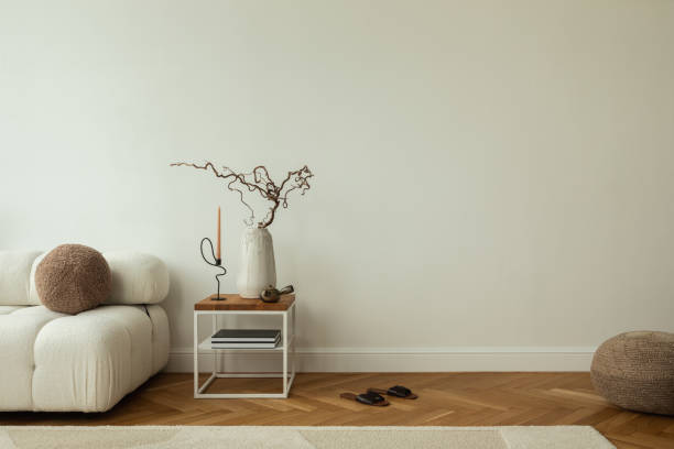istock A modern living room with a white sofa, wooden side table, and neutral decor. Home decor.  Books, slippers, and a coffee cup add a cozy touch. Template. Copy space. 2178686563