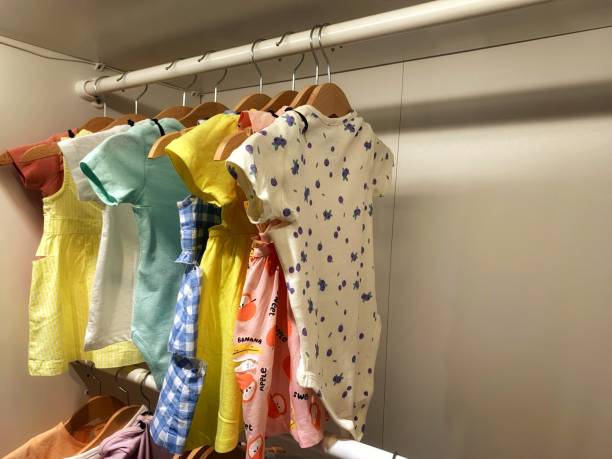 istock Dry-cleaning service. Many different Baby clothes hanging on rack against white background, space for text 2178686757