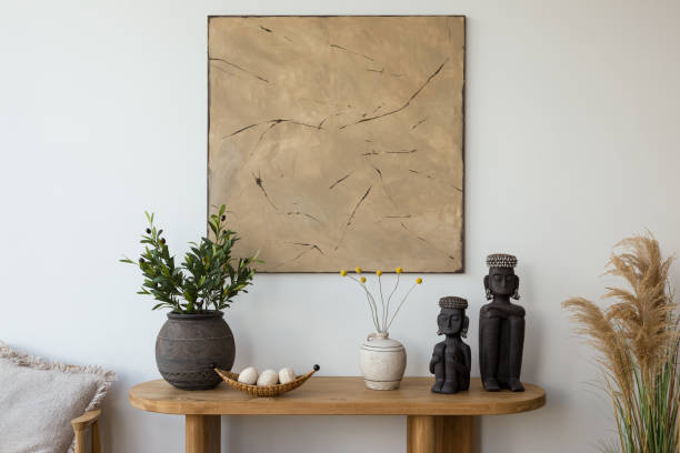 istock Aesthetic interior design featuring a wooden console table and chair  adorned with decorative vases, candles, and  sculptures. A large abstract painting adds a modern touch. Stylish space. Template. 2178689837