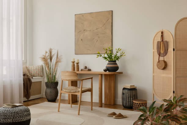 istock Modern home office with a minimalist design, featuring a wooden desk with decorative items, a chair, and potted plants. A doorway reveals a cozy adjoining room. Natural light enhances the warm, tranquil atmosphere. 2178689912