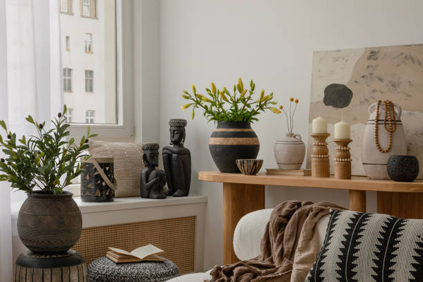 istock Cozy and boho  living room featuring a white sofa with textured cushions and blankets, a wooden coffee table with decorations, and decorative elements in natural tones. Stylish home interior. Template. 2178689918