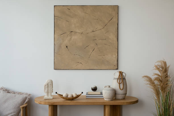 istock Aesthetic interior design featuring a wooden console, furniture  adorned with decorative vases, candles and  sculptures. A large abstract painting adds a modern touch. Stylish space. Template. 2178689942
