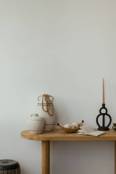 istock Interior design of boho home office place with wooden console, decorations, candle, personal accessories and copy space. white wall. Template. 2178689948