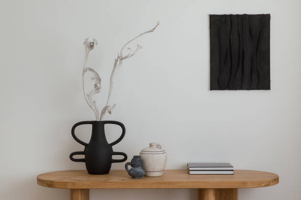 Contemporary console table with ceramic vases. Elegant console with a striking black vase and sculptural elements, perfect for modern interiors. Mock up paintings.