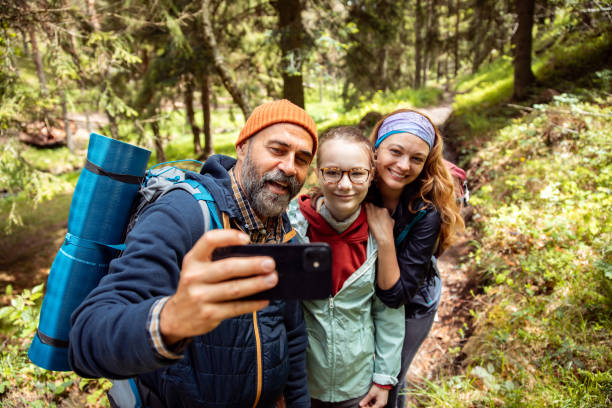 istock Young family taking a selfie while hiking in a forest 2178690988