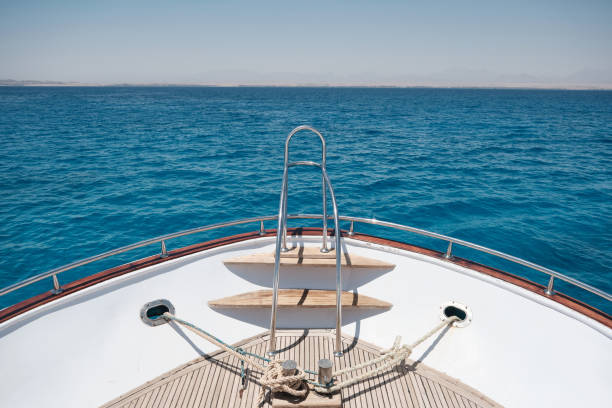 Boat deck. Wide angle view of the yacht front with metal handrails opposite blue sea