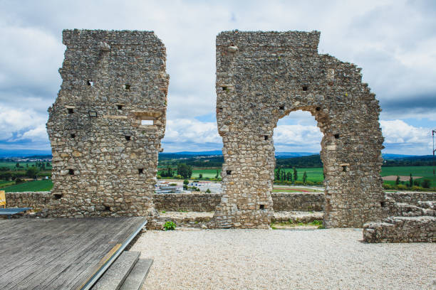 istock A stone ruin with an arched opening stands against a backdrop of green fields and distant hills, highlighting the contrast between the remnants of ancient architecture 2178691895